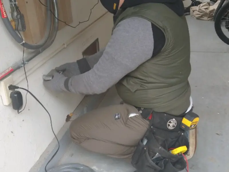 Electrician performing outlet wiring in a Stow garage